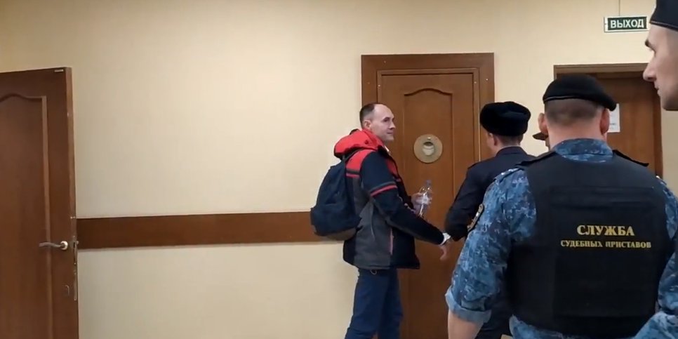 The bailiffs take away handcuffed Alexey Gerasimov. December 2023