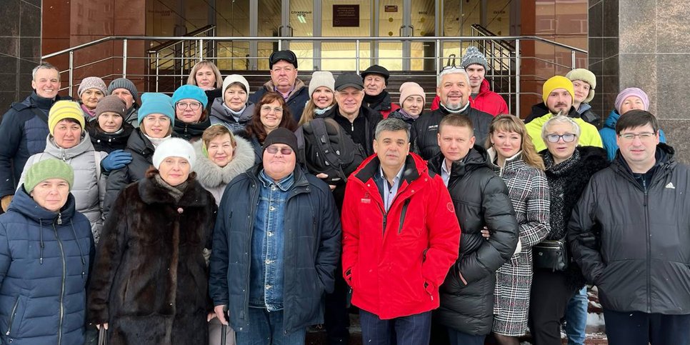 Anatoliy Isakov com seus amigos em frente ao prédio do tribunal